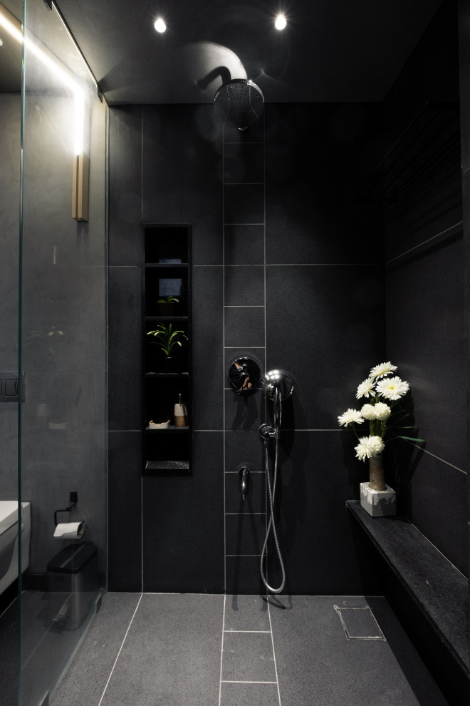 Design ideas for a large contemporary 3/4 bathroom in Other with an alcove shower, a wall-mount toilet, black tile, porcelain tile, black walls, porcelain floors, grey floor, a niche and a shower seat.