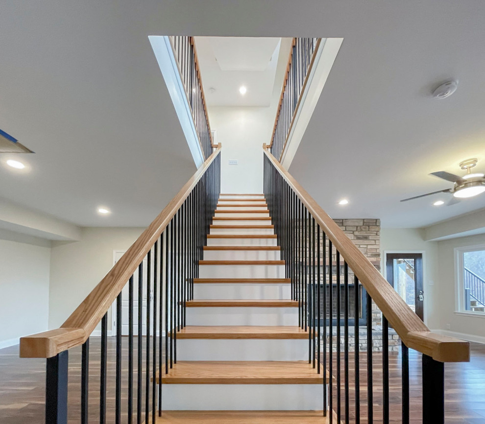 Idée de décoration pour un grand escalier flottant tradition avec des marches en bois, des contremarches en bois, un garde-corps en matériaux mixtes et du lambris de bois.