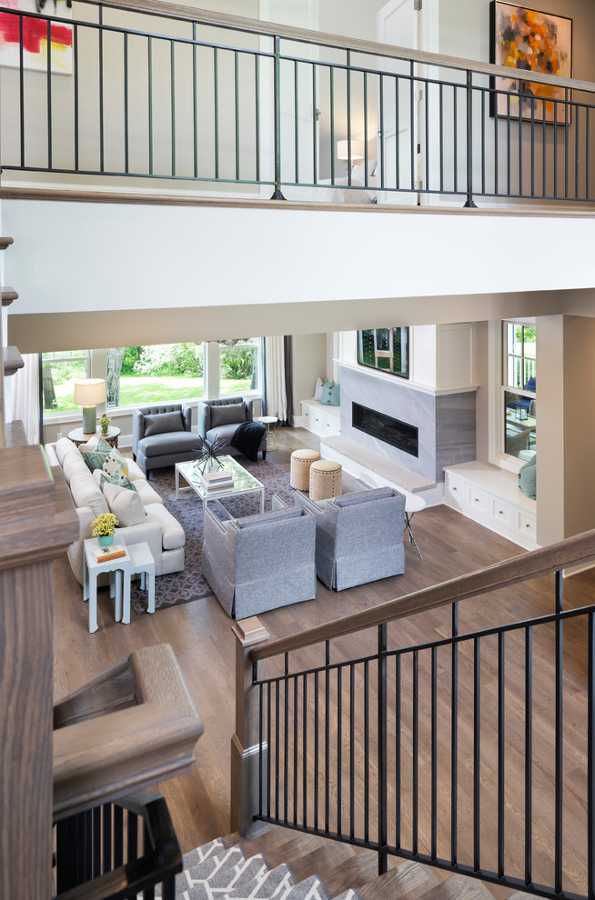 Large transitional carpeted u-shaped staircase in Minneapolis with wood risers and metal railing.