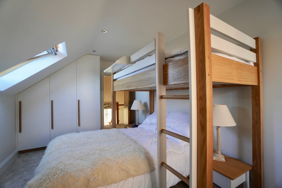 Immagine di una camera degli ospiti minimal di medie dimensioni con pareti bianche, moquette, pavimento grigio, soffitto a volta e carta da parati