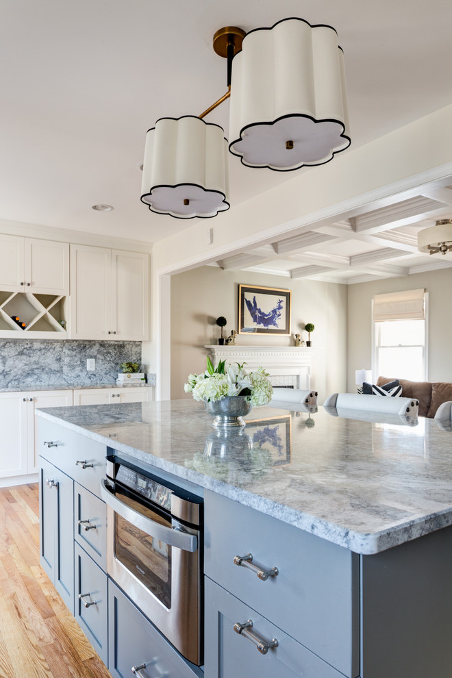Inspiration for a transitional light wood floor kitchen pantry remodel with a single-bowl sink, shaker cabinets, gray cabinets, quartzite countertops, gray backsplash, stone slab backsplash, stainless steel appliances and an island