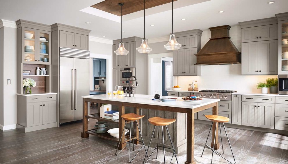 Inspiration for a large transitional l-shaped eat-in kitchen in Kansas City with an undermount sink, recessed-panel cabinets, grey cabinets, quartz benchtops, white splashback, stone slab splashback, stainless steel appliances, ceramic floors, with island and brown floor.