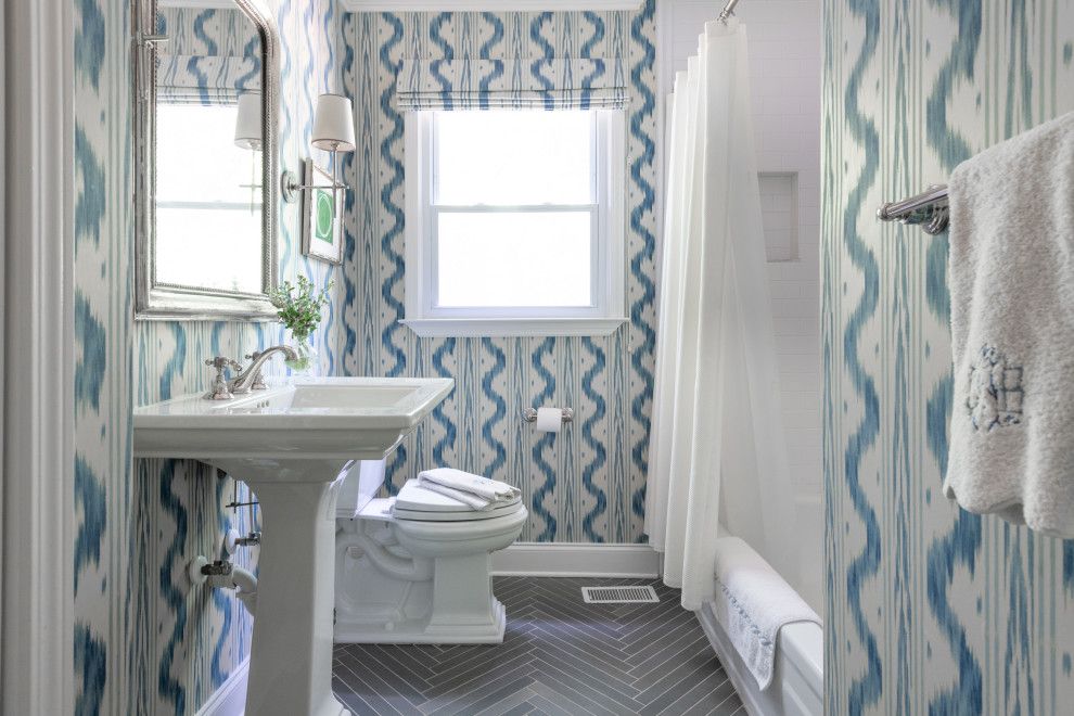 Cette photo montre une petite salle de bain chic avec un combiné douche/baignoire, un bidet, un mur bleu, un sol en carrelage de céramique, un lavabo de ferme, un sol gris, meuble simple vasque, meuble-lavabo sur pied et du papier peint.