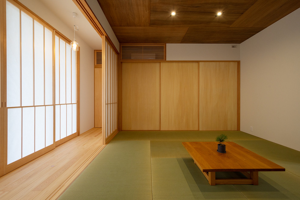 Идея дизайна: большая изолированная гостиная комната с бежевыми стенами, татами, отдельно стоящим телевизором, зеленым полом, деревянным потолком и обоями на стенах без камина