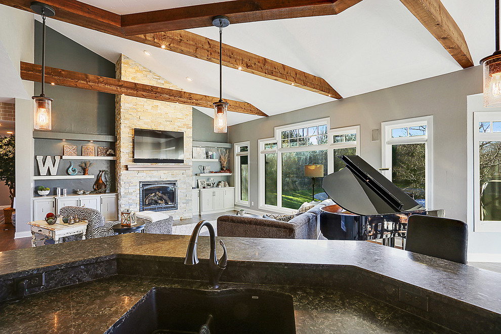 Example of a mountain style dark wood floor home design design with gray walls, a standard fireplace and a stone fireplace