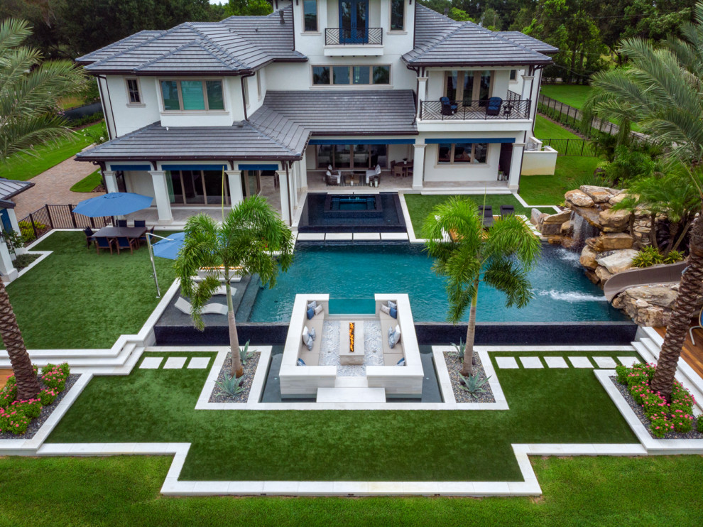 Large contemporary backyard custom-shaped infinity pool in Tampa with with a pool and tile.