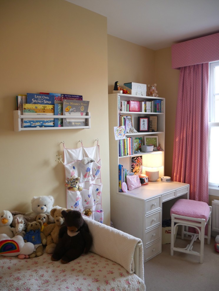 Immagine di una cameretta per bambini da 4 a 10 anni moderna di medie dimensioni con pareti gialle, moquette e pavimento beige