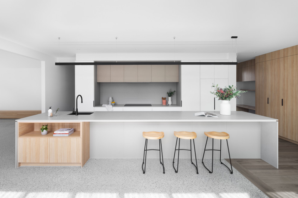 Große Moderne Küche mit Vorratsschrank, Kücheninsel, Unterbauwaschbecken, Küchenrückwand in Grau, Rückwand aus Stein, schwarzen Elektrogeräten, Betonboden, grauem Boden und grauer Arbeitsplatte in Melbourne