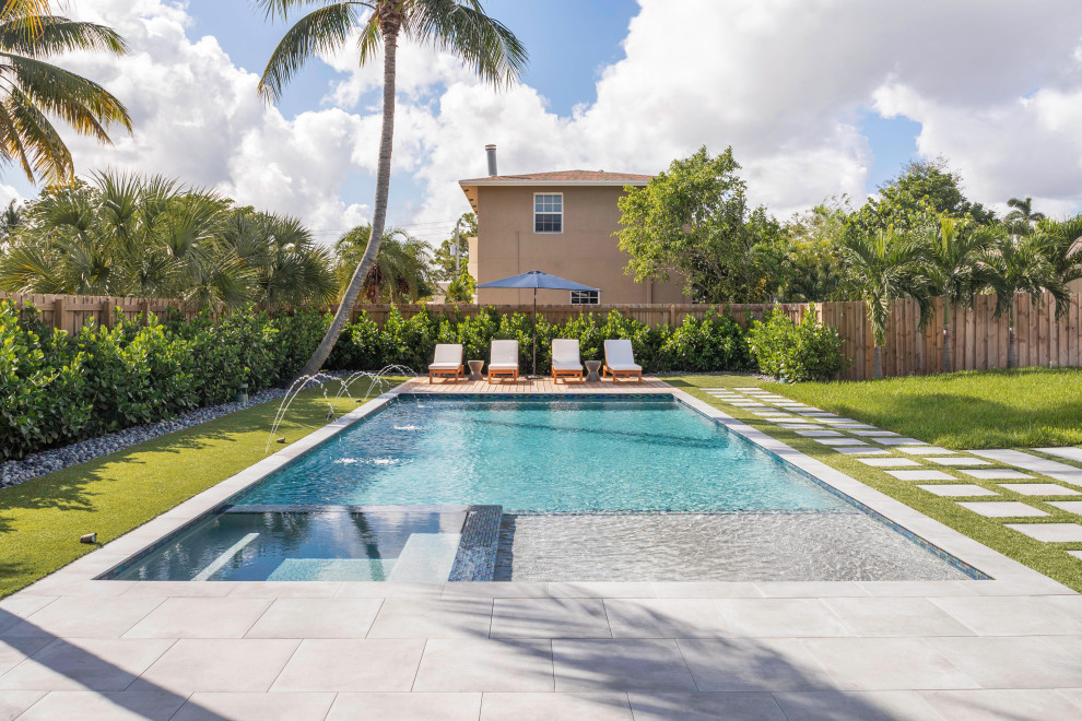 Design ideas for a mid-sized contemporary backyard rectangular lap pool in Miami with a hot tub.