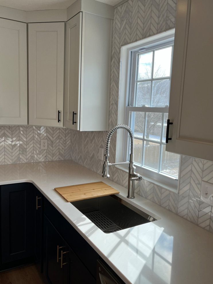 Bild på ett mellanstort funkis vit vitt kök, med en undermonterad diskho, skåp i shakerstil, blå skåp, bänkskiva i kvartsit, grått stänkskydd, stänkskydd i keramik, rostfria vitvaror, vinylgolv och en köksö