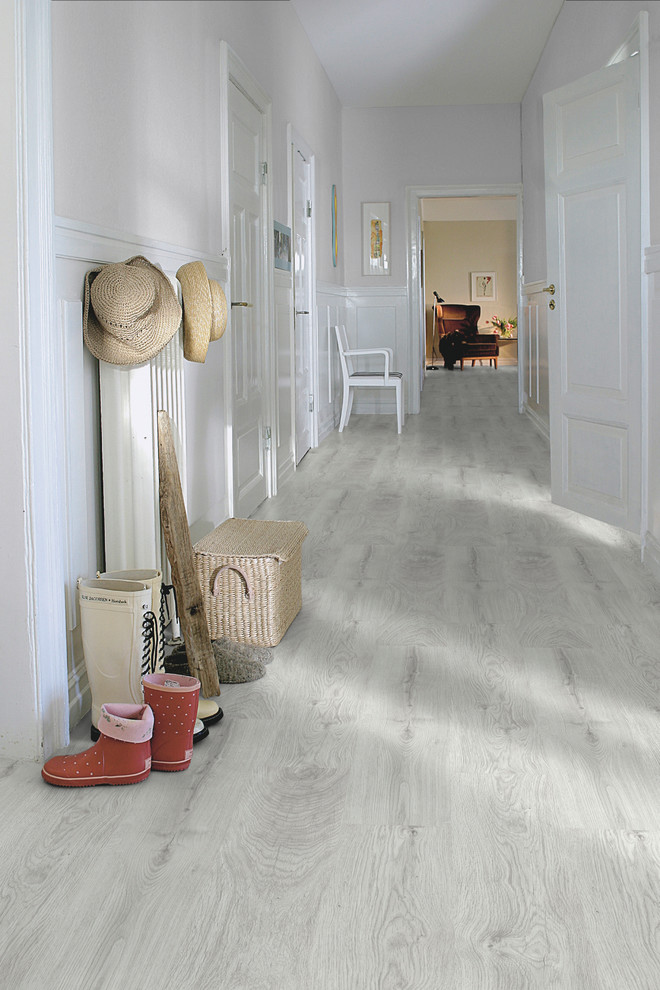 Photo of a large country hallway in Other with white walls and light hardwood floors.