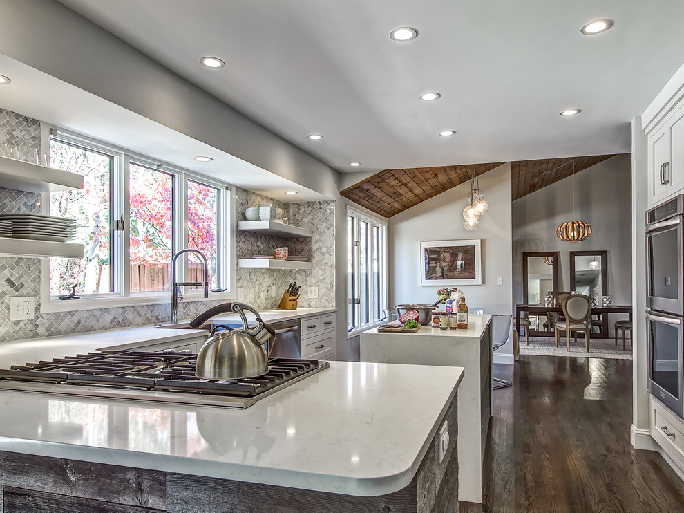 Example of a transitional dark wood floor kitchen design in Denver with a farmhouse sink, shaker cabinets, white cabinets, quartz countertops, stone tile backsplash and an island