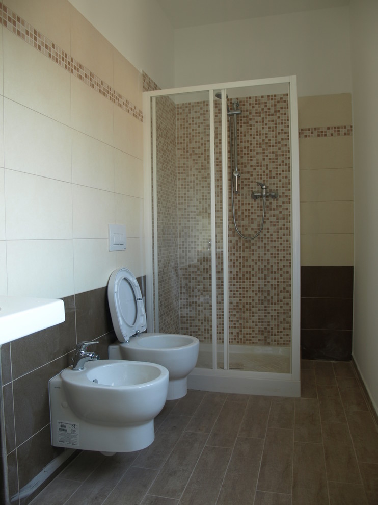This is an example of a small contemporary master bathroom in Milan with open cabinets, a corner shower, a two-piece toilet, brown tile, porcelain tile, beige walls, porcelain floors, a trough sink, brown floor and a sliding shower screen.