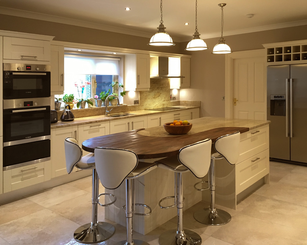 Design ideas for a Medium Sized country U-shaped kitchen/diner with a Built-in Sink, Recessed-panel Cabinets, Beige Cabinets, Marble Worktops, Beige Splashback, Marble Splashback, Black Appliances, Porcelain Flooring, an Island and Beige Floors.