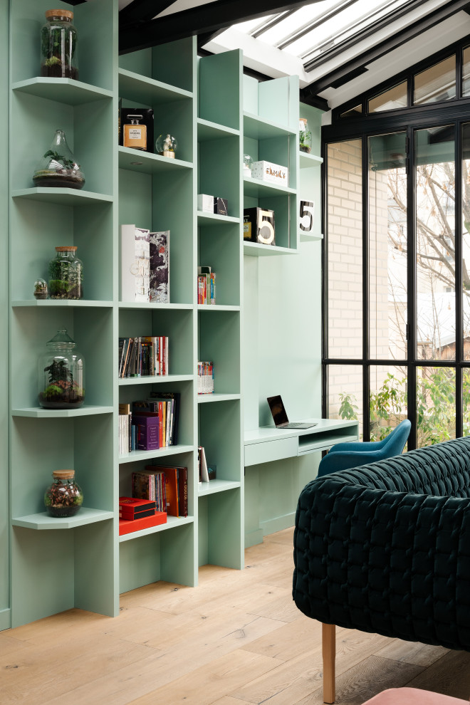 Idee per un soggiorno contemporaneo con libreria, pareti blu, parquet chiaro, pavimento beige e travi a vista
