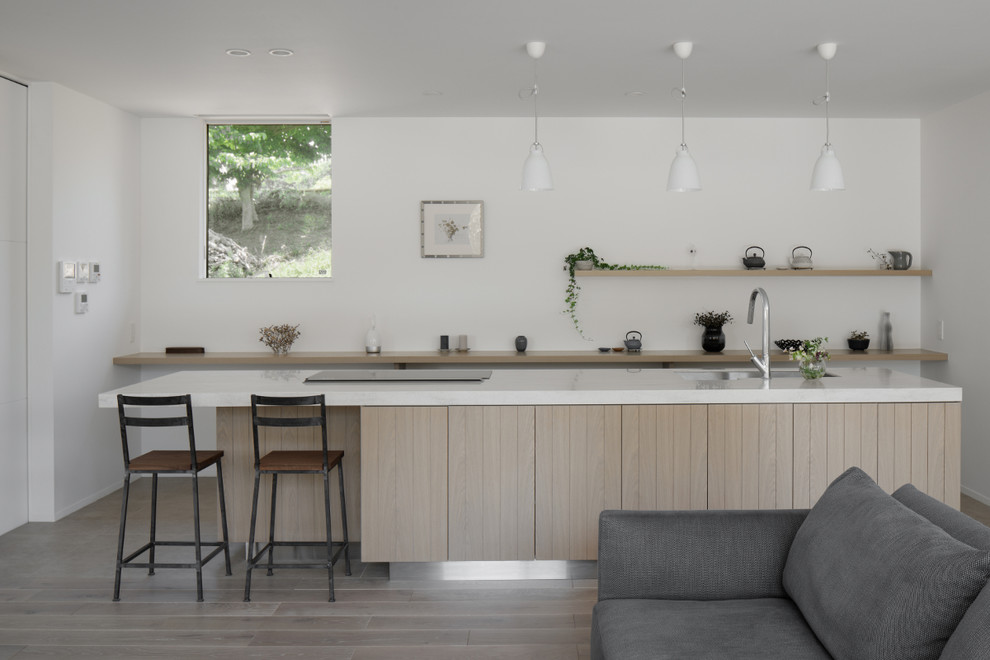 Design ideas for a modern single-wall open plan kitchen in Other with grey cabinets, painted wood floors, with island, grey floor, an undermount sink, beaded inset cabinets, solid surface benchtops, black appliances and beige benchtop.