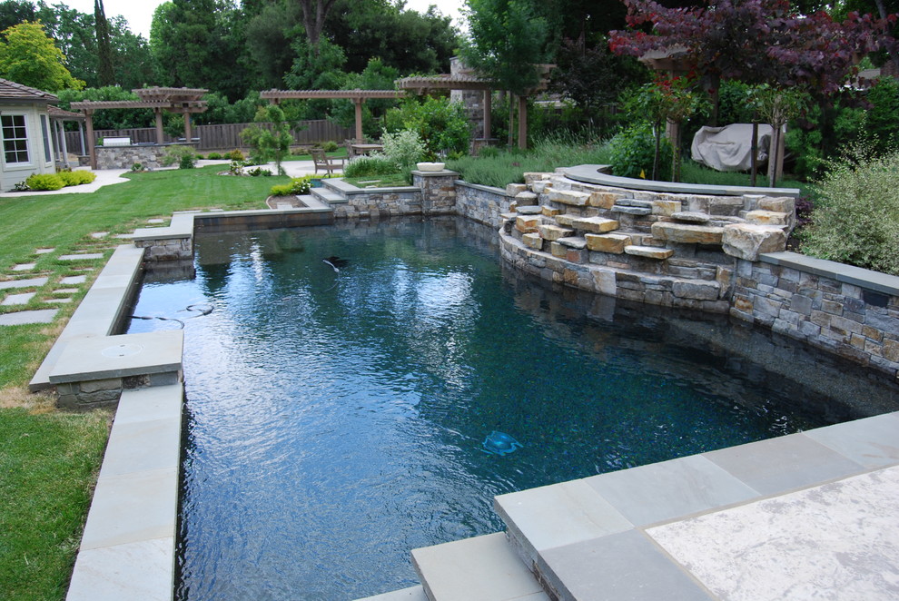 Design ideas for an expansive arts and crafts backyard custom-shaped pool in San Francisco with a water feature and stamped concrete.