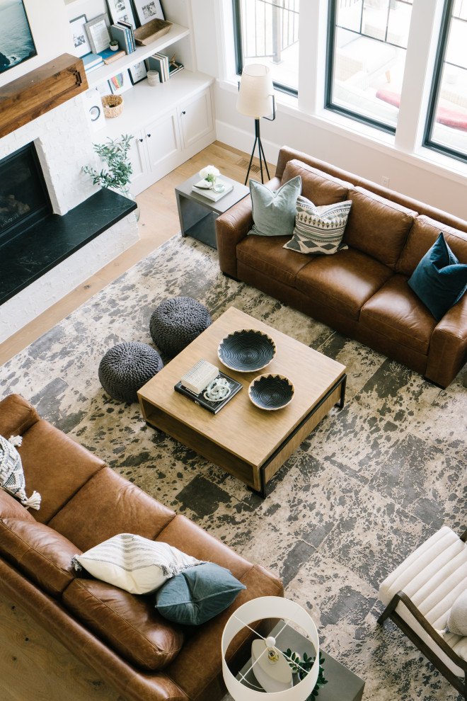 Large transitional open concept light wood floor, brown floor and vaulted ceiling family room photo in Salt Lake City with white walls, a standard fireplace, a brick fireplace and a wall-mounted tv
