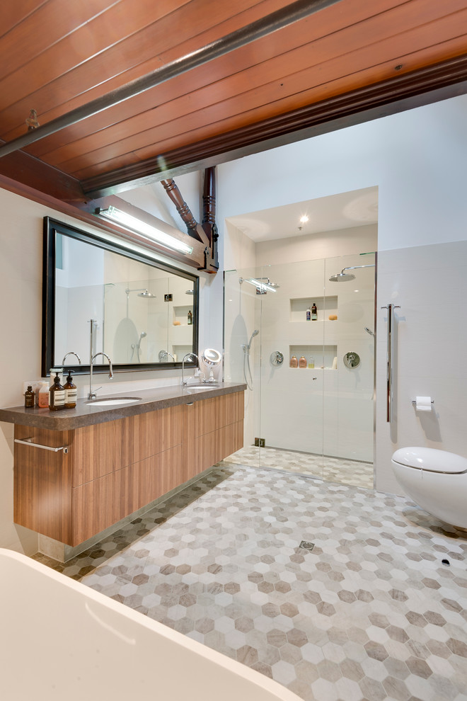Contemporary bathroom in Melbourne with an undermount sink, engineered quartz benchtops, a freestanding tub, porcelain tile, flat-panel cabinets, medium wood cabinets, an alcove shower, white tile and white walls.