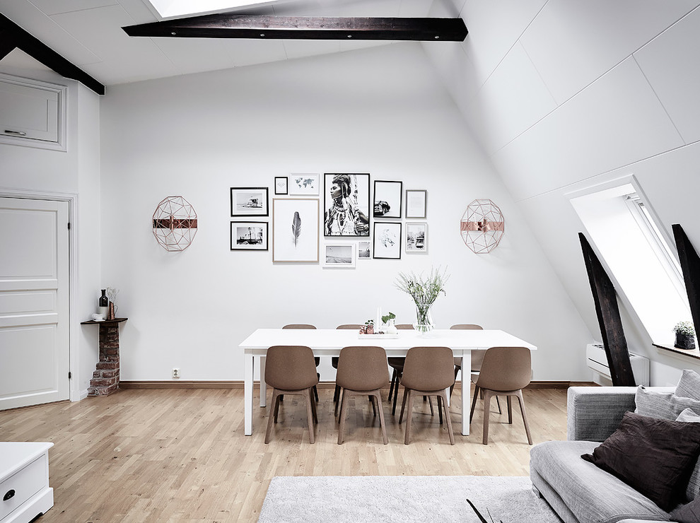 Photo of a scandinavian dining room in Gothenburg with white walls, light hardwood floors and beige floor.