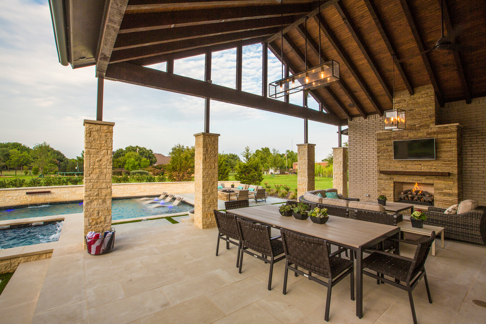 Photo of a large traditional backyard patio in Dallas with natural stone pavers, a roof extension and with fireplace.
