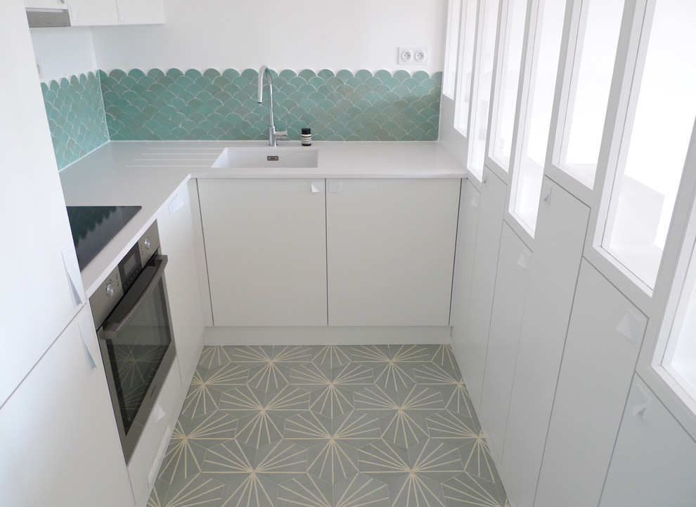 Design ideas for a small contemporary u-shaped open plan kitchen in Paris with an undermount sink, flat-panel cabinets, white cabinets, quartzite benchtops, green splashback, ceramic splashback, panelled appliances, cement tiles, no island, turquoise floor and white benchtop.