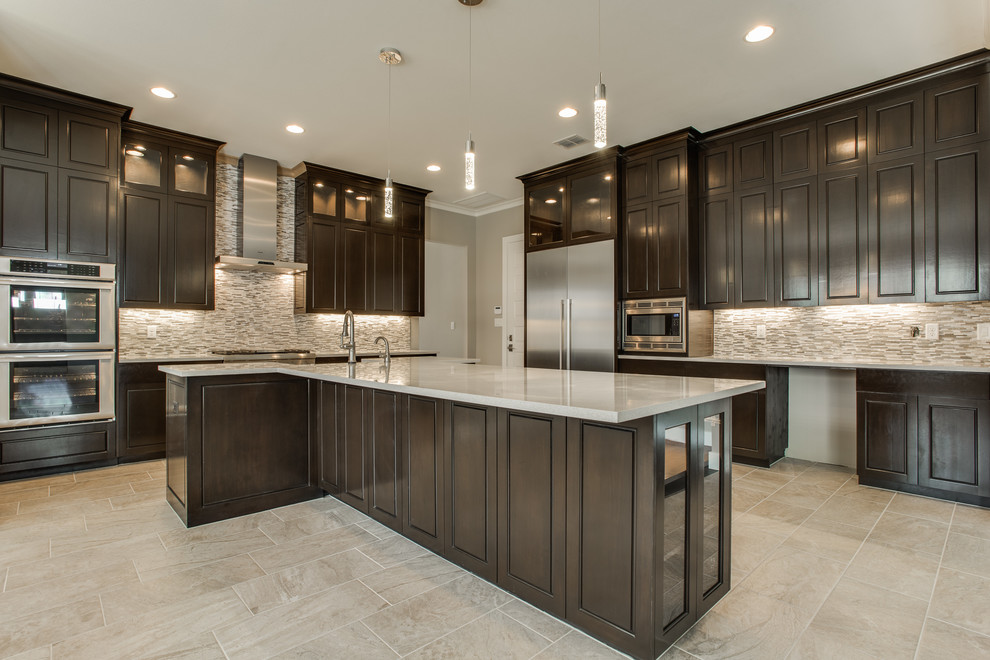Large transitional l-shaped kitchen in Dallas with a farmhouse sink, raised-panel cabinets, dark wood cabinets, quartz benchtops, beige splashback, glass tile splashback, stainless steel appliances, porcelain floors and with island.