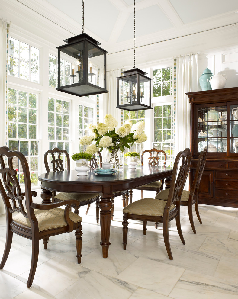 This is an example of a traditional dining room in Atlanta with white walls and marble floors.
