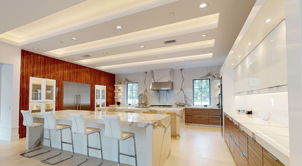 オレンジカウンティにある高級な巨大なモダンスタイルのおしゃれなキッチン (シングルシンク、フラットパネル扉のキャビネット、クオーツストーンカウンター、白いキッチンパネル、石スラブのキッチンパネル、シルバーの調理設備、磁器タイルの床、ベージュの床、白いキッチンカウンター、折り上げ天井) の写真