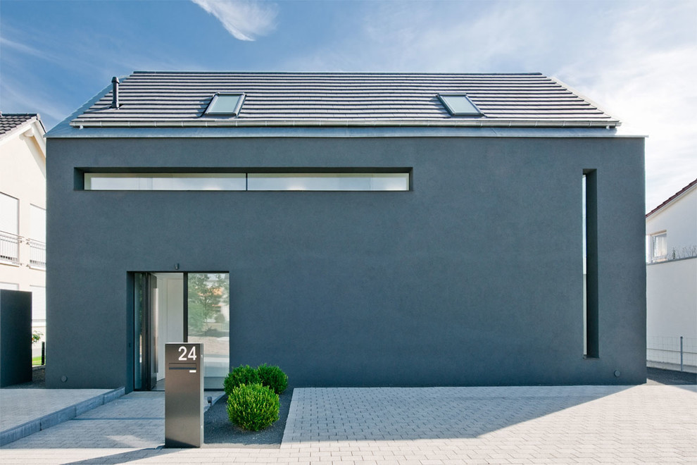Photo of a contemporary two-storey grey exterior in Berlin with a gable roof.
