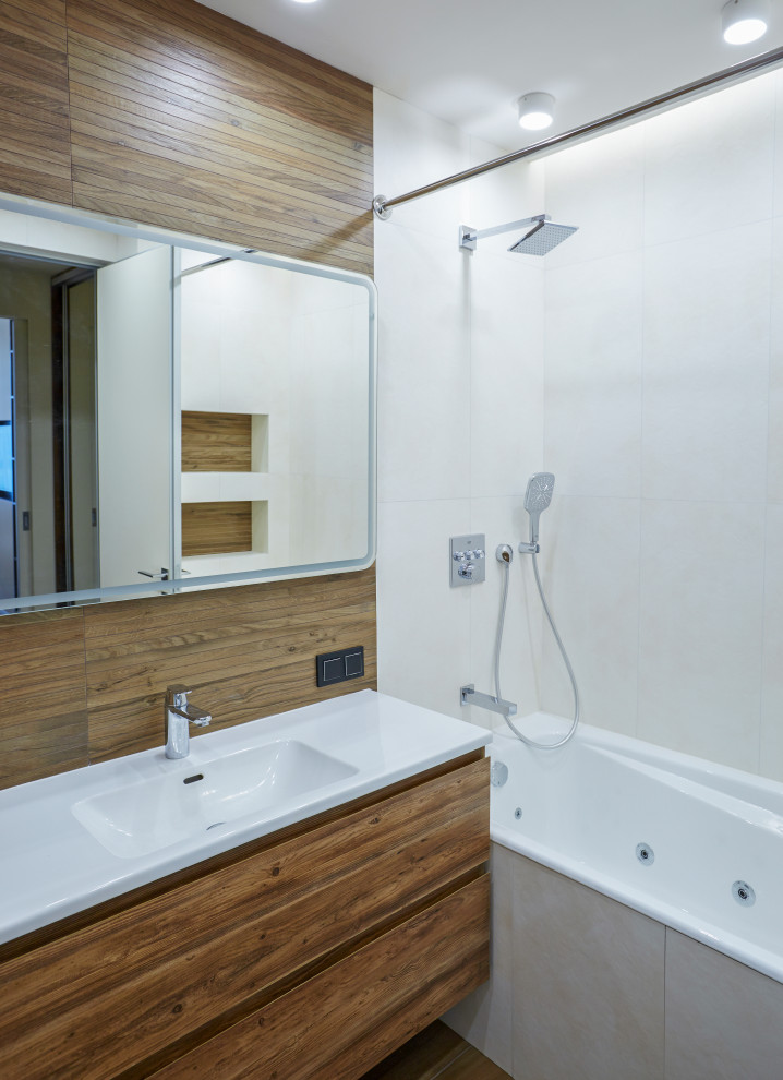 Idéer för ett stort modernt vit en-suite badrum, med en vägghängd toalettstol, brun kakel, keramikplattor, vita väggar, klinkergolv i porslin, ett väggmonterat handfat, bänkskiva i akrylsten och brunt golv