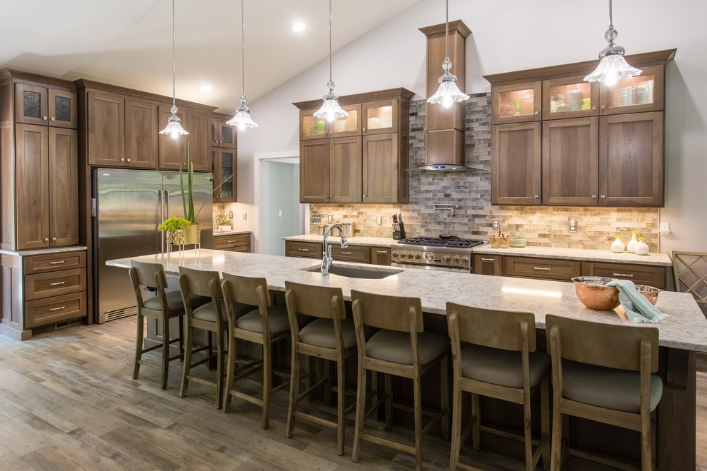 Example of a transitional l-shaped open concept kitchen design with shaker cabinets, stainless steel appliances and an island