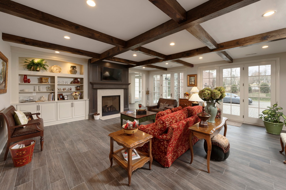 Design ideas for a mid-sized traditional open concept living room in DC Metro with porcelain floors, a standard fireplace, a stone fireplace surround, a wall-mounted tv and grey floor.