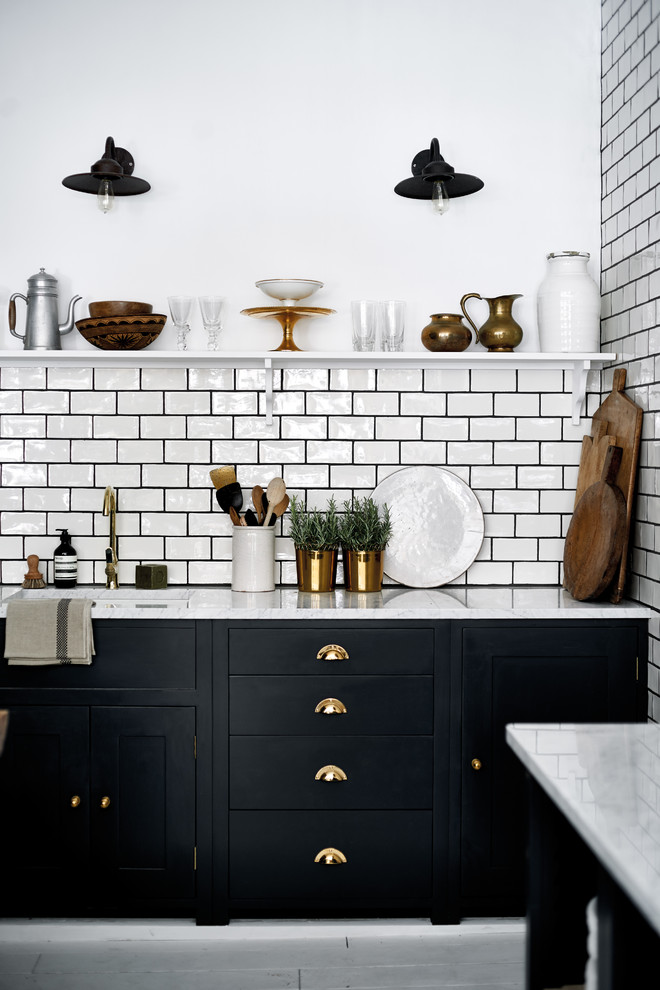 Inspiration for a large country galley open plan kitchen in Dusseldorf with glass-front cabinets, black cabinets, white splashback, subway tile splashback, painted wood floors and with island.