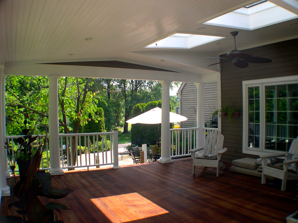 This is an example of a mid-sized traditional backyard deck in Philadelphia with a roof extension.