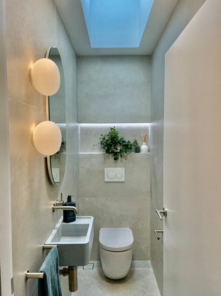 Esempio di un piccolo bagno di servizio design con ante blu, WC monopezzo, piastrelle grigie, piastrelle in ceramica, pareti grigie, pavimento con piastrelle in ceramica, lavabo sospeso, pavimento grigio e mobile bagno sospeso