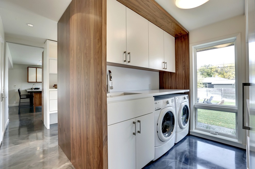 Photo of a modern galley laundry room in Minneapolis with flat-panel cabinets, white cabinets, white walls, a side-by-side washer and dryer, blue floor and white benchtop.