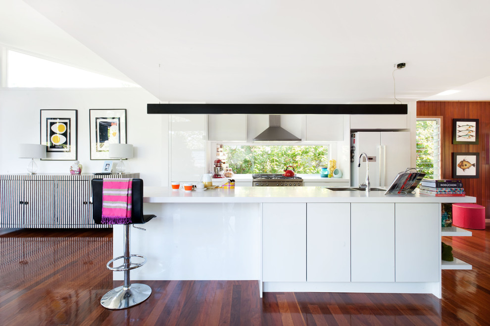 Design ideas for a mid-sized contemporary galley eat-in kitchen in Brisbane with flat-panel cabinets, white cabinets, window splashback, stainless steel appliances, dark hardwood floors, brown floor, a double-bowl sink and with island.