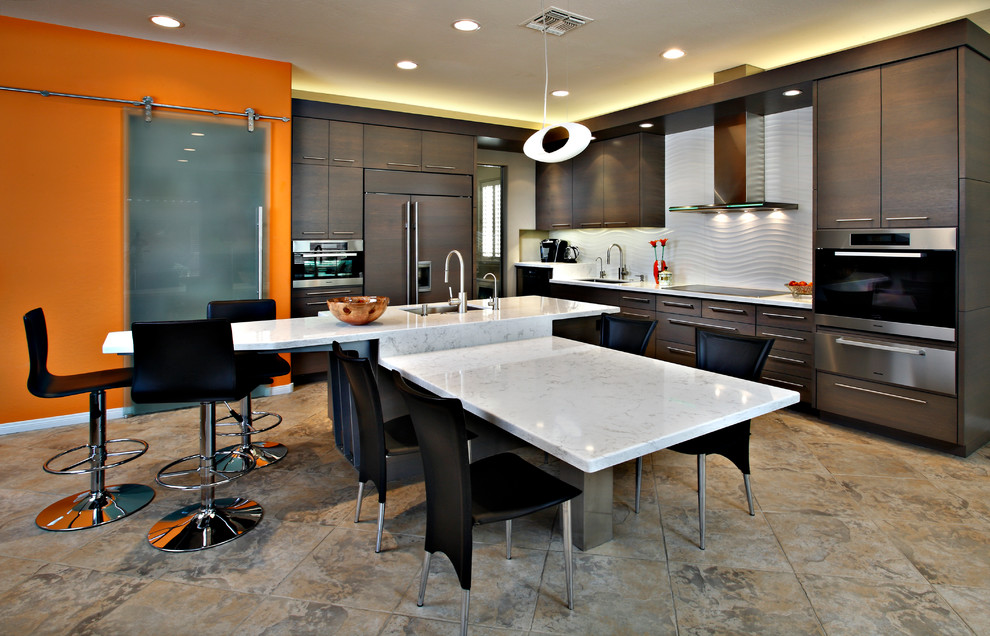 Trendy l-shaped eat-in kitchen photo in Phoenix with dark wood cabinets, an undermount sink, flat-panel cabinets, white backsplash and paneled appliances