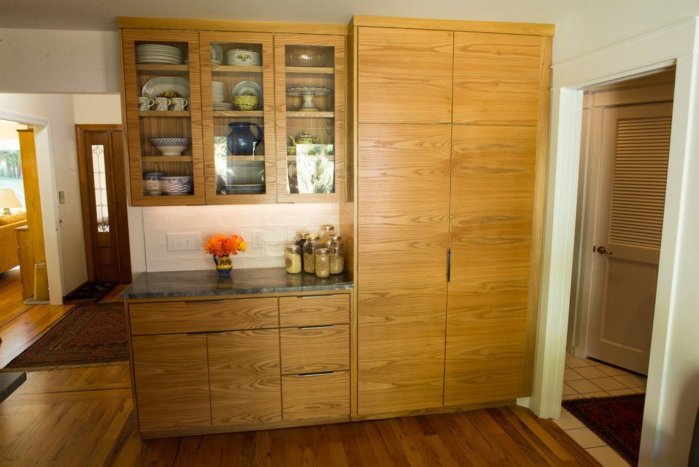 Eat-in kitchen - mid-sized transitional u-shaped medium tone wood floor eat-in kitchen idea with an undermount sink, flat-panel cabinets, medium tone wood cabinets, quartzite countertops, white backsplash, ceramic backsplash, stainless steel appliances and an island