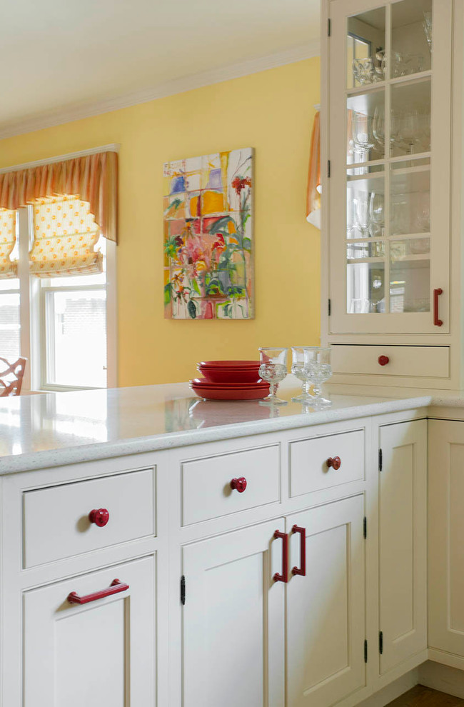Design ideas for a large eclectic galley eat-in kitchen in Boston with a drop-in sink, glass-front cabinets, white cabinets, soapstone benchtops, yellow splashback, stone tile splashback, white appliances, light hardwood floors and with island.