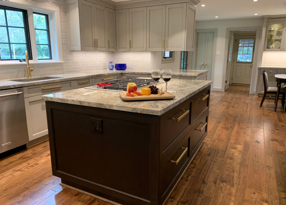 Inspiration for an expansive modern u-shaped open plan kitchen in Houston with an undermount sink, shaker cabinets, grey cabinets, quartzite benchtops, grey splashback, porcelain splashback, stainless steel appliances, light hardwood floors, with island, brown floor and blue benchtop.