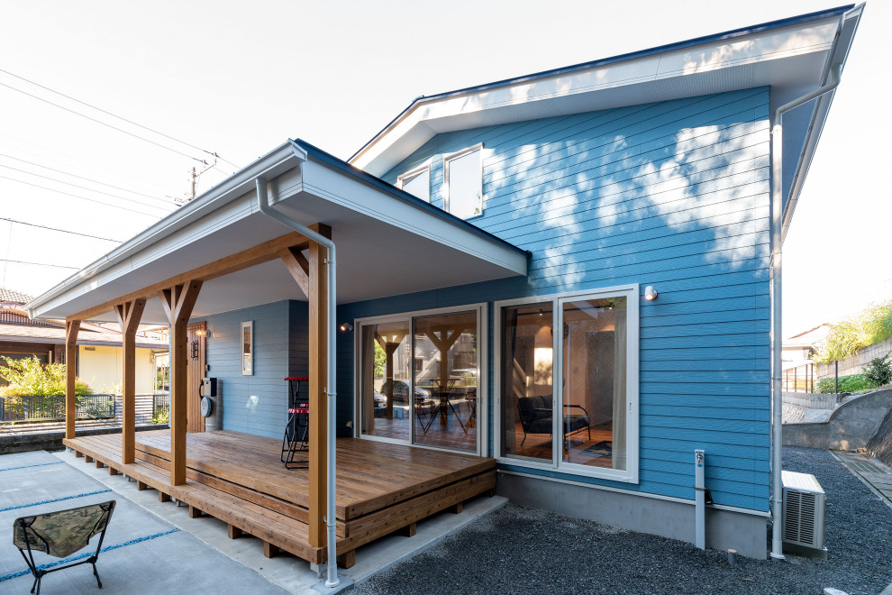 Immagine della villa blu stile marinaro a un piano di medie dimensioni con copertura in metallo o lamiera, tetto blu e tetto a capanna