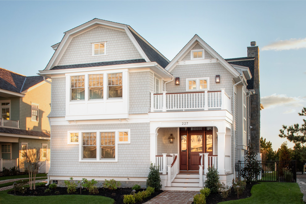 Photo of a beach style two-storey grey house exterior in Philadelphia with wood siding, a gambrel roof and a shingle roof.