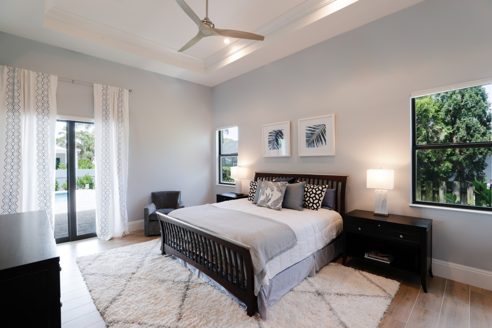 Foto de habitación de invitados blanca y blanca y madera costera con paredes grises, suelo de madera clara, suelo marrón y bandeja
