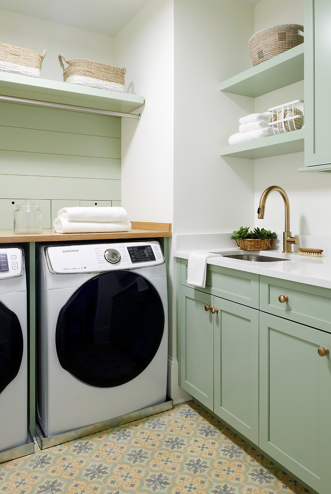 Beach style l-shaped dedicated laundry room in Philadelphia with an undermount sink, shaker cabinets, green cabinets, white walls, a side-by-side washer and dryer, multi-coloured floor, white benchtop and quartz benchtops.