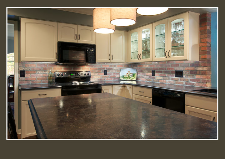 Exempel på ett mellanstort klassiskt kök, med en undermonterad diskho, luckor med upphöjd panel, vita skåp, granitbänkskiva, rött stänkskydd, stänkskydd i stenkakel, svarta vitvaror, mellanmörkt trägolv och en köksö