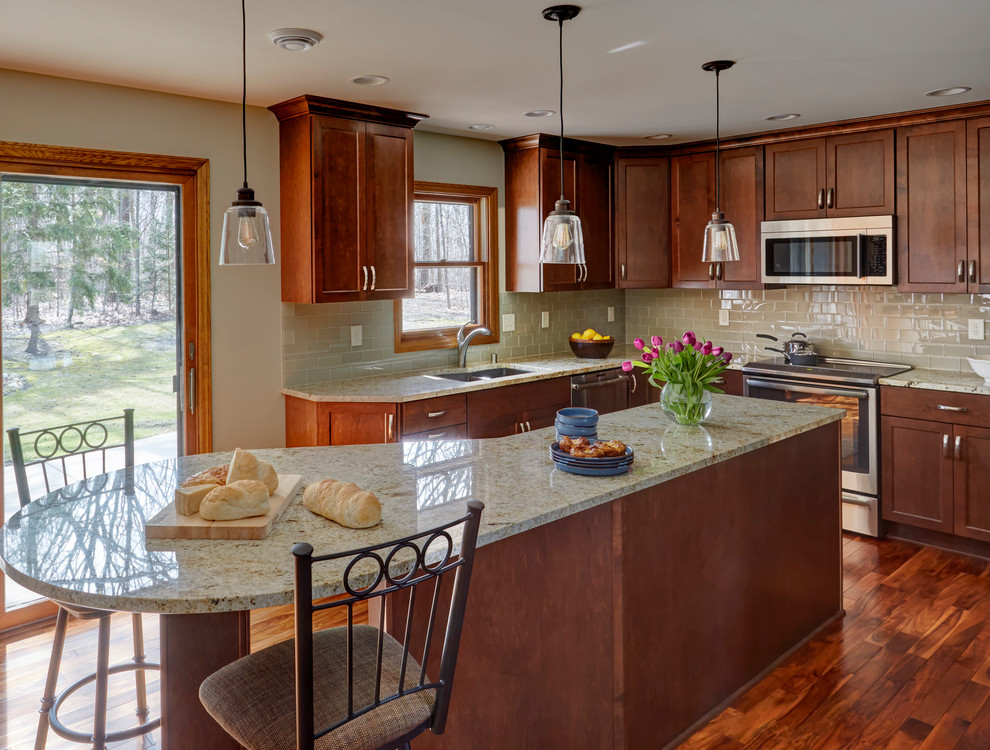 Eat-in kitchen - mid-sized transitional l-shaped dark wood floor and brown floor eat-in kitchen idea in Milwaukee with an undermount sink, shaker cabinets, dark wood cabinets, granite countertops, beige backsplash, subway tile backsplash, stainless steel appliances and an island