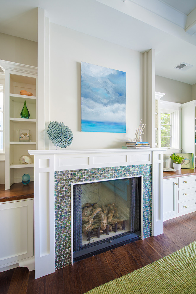 Design ideas for a beach style open concept family room in Los Angeles with white walls, medium hardwood floors, a standard fireplace, a tile fireplace surround and no tv.