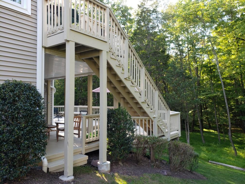 На фото: большая прямая деревянная лестница в классическом стиле с деревянными перилами, деревянными ступенями и деревянными стенами